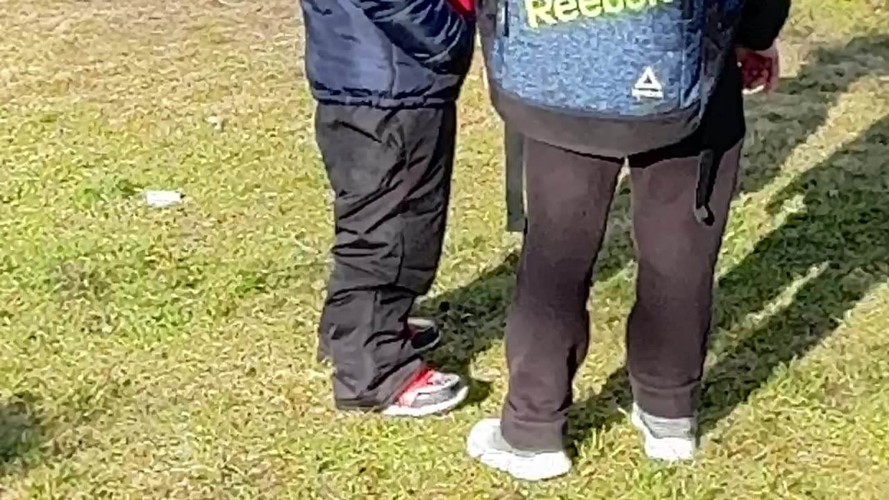 My grandson standing outside the school and talking his friends