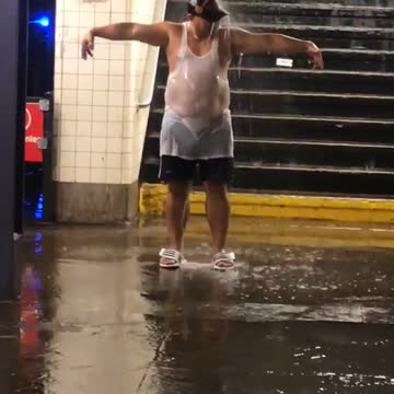 Man with hat and white shirt under water falling