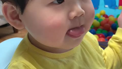 Cute baby watching TV while eating bread