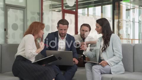 Work Team Composed Of Two Females And Two Males Around A Laptop Put Issues In Common 1