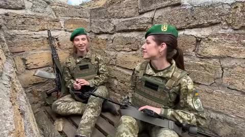 A duet in the trenches. Ukrainian female border guards sing a song enjoying a moment of calm.