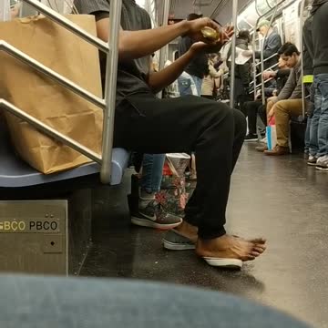 Shoeless man purells hands and feet on subway