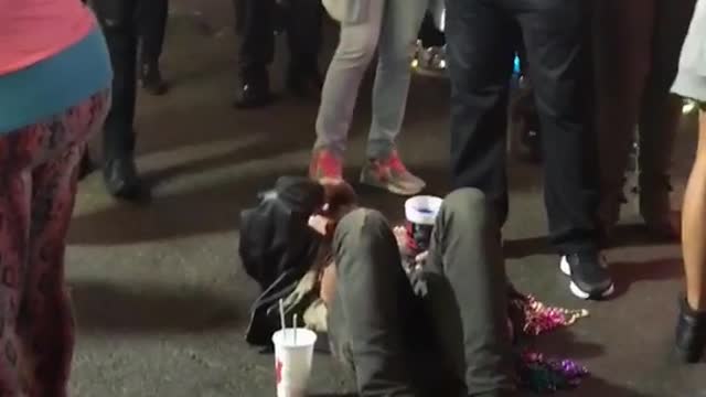 Guy laying down on ground people walking over him