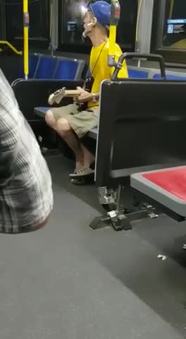 Old man in yellow shirt plays electric guitar