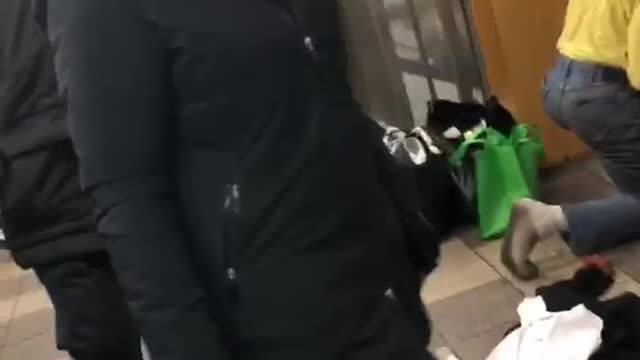 Man wiping subway floor has dirty black socks