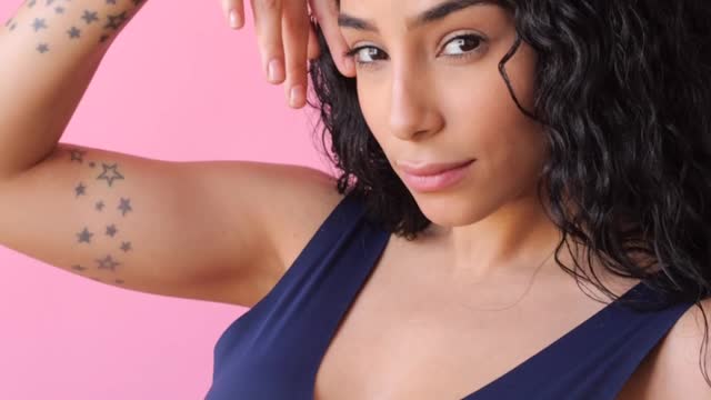 woman-looking-at-camera-while-touching-her-face