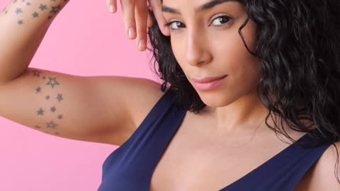 woman-looking-at-camera-while-touching-her-face