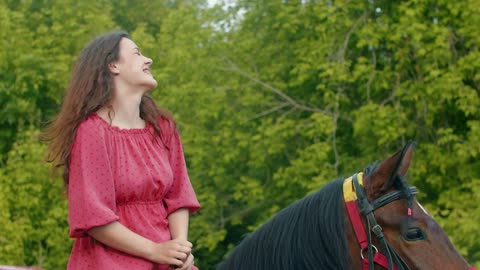 Young smiling woman with braces in pink dress riding a horse