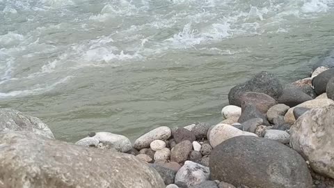 the view of the rocks on the side of the river with rushing water