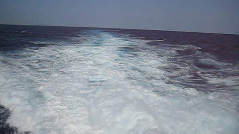 The churning wake of 20 knots on the USS HARPERS FERRY