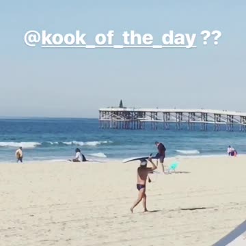 Guy in speedo balancing surfboard on head