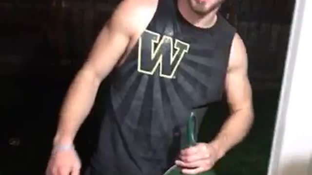 Guy in black tank top cracks beer over his head