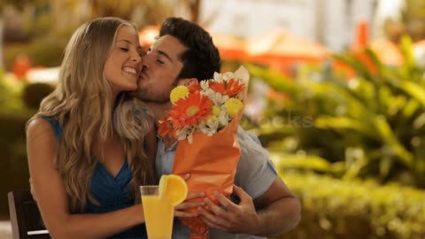 young couple man giving flowers to girl in park_