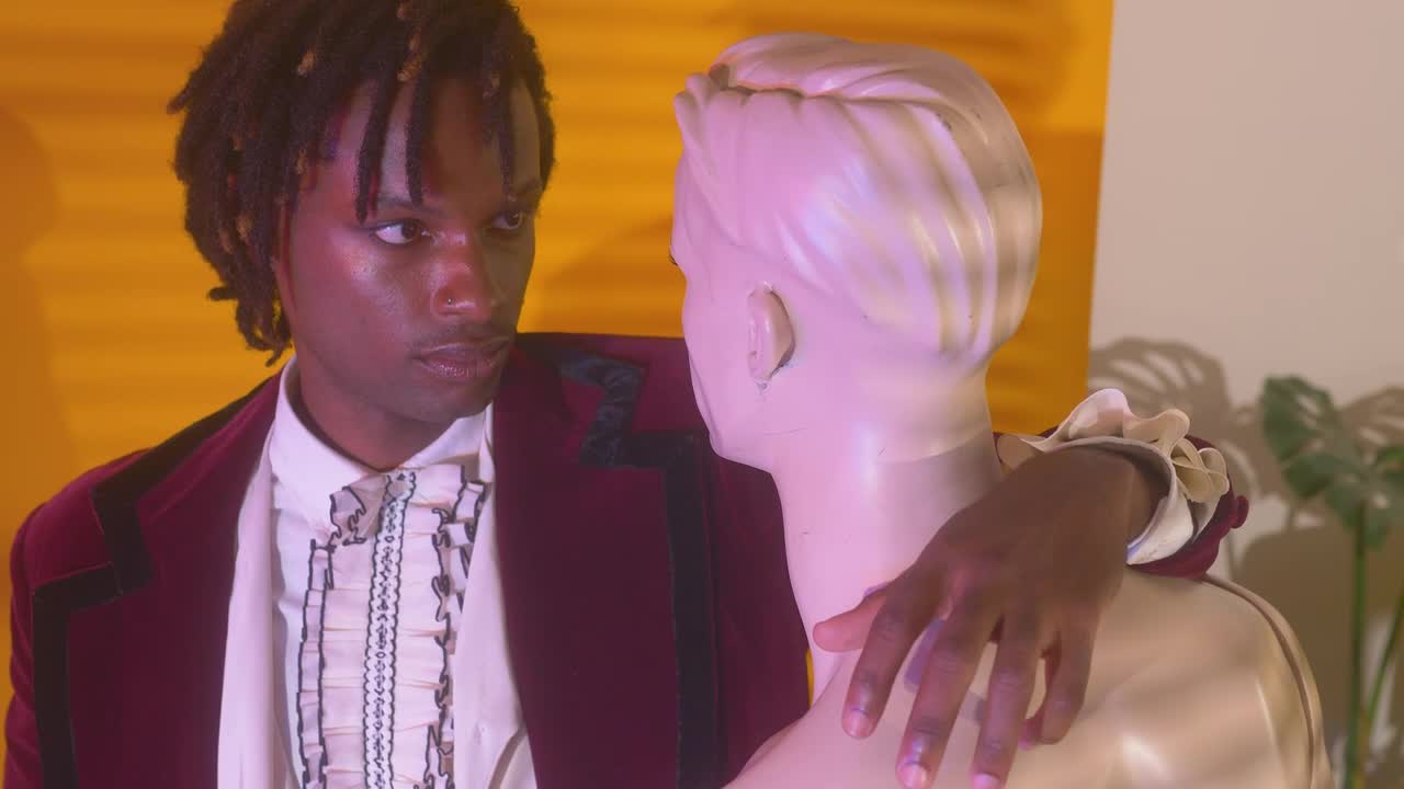 Elegant man hugging and staring at a mannequin