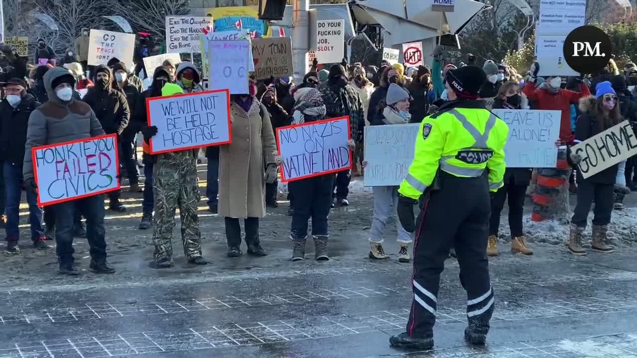 Counter-protestors against the Freedom Convoy shout “do your job” at the police