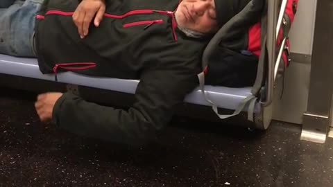 Man black jacket beanie asleep on train