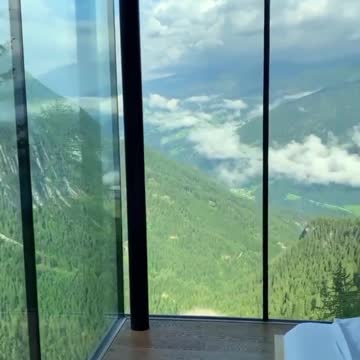 "Majestic Vista: A Green Mountain and Cloudy Sky View from the Bedroom Window"