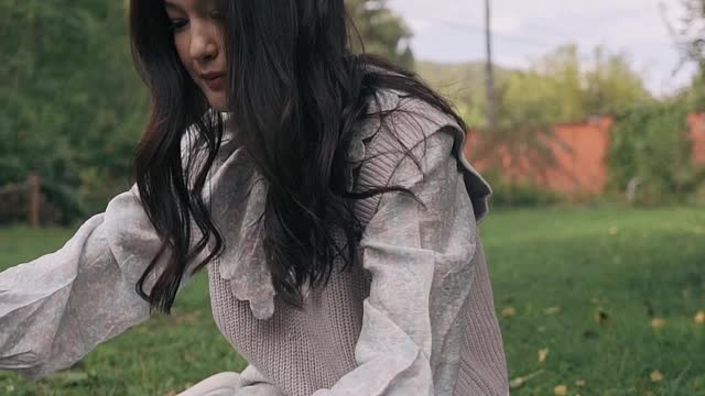 a-woman-playing-with-a-cat-on-the-grass