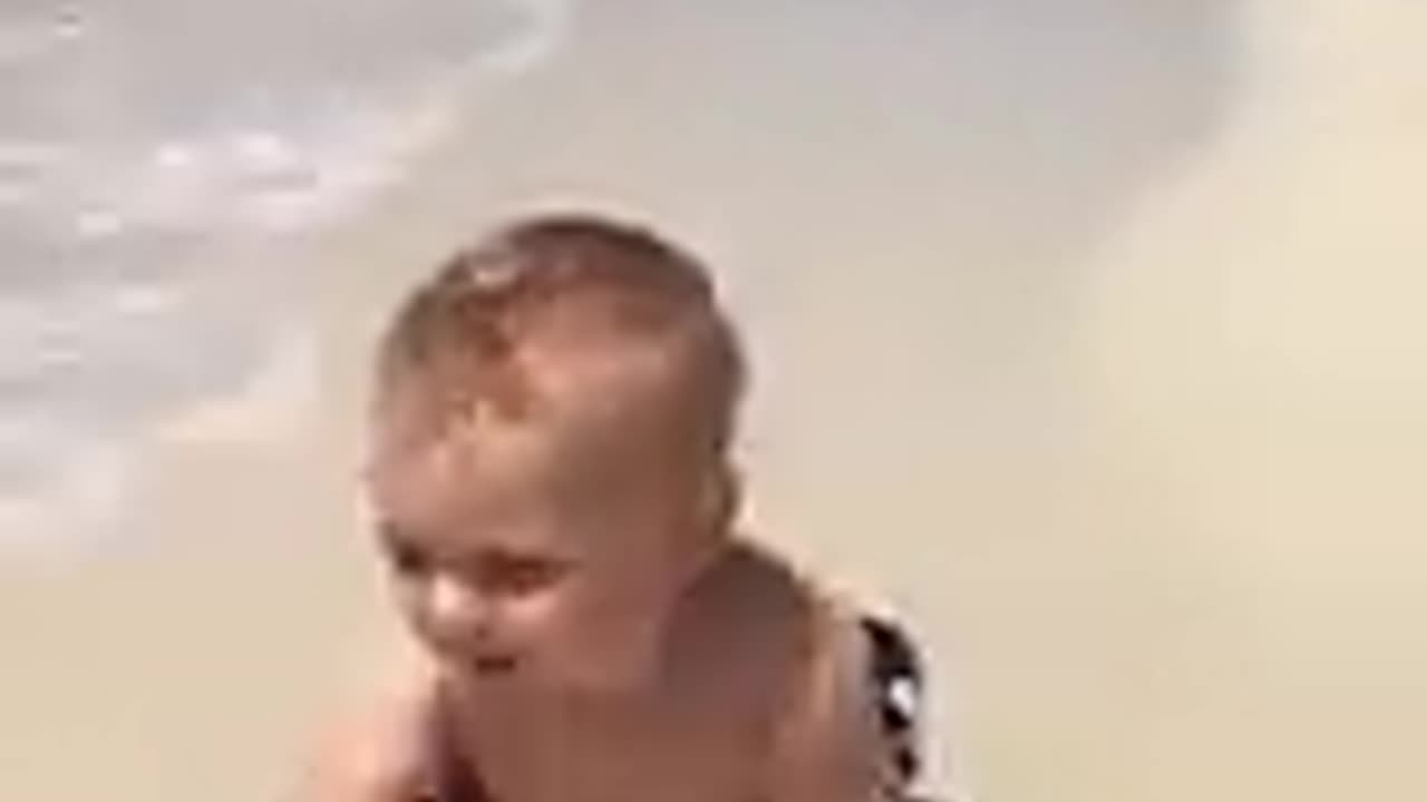 Funny baby reaction on the beach