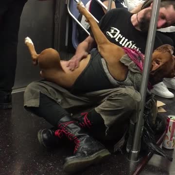 Guy on subway holds brown dog on back and rubs its belly
