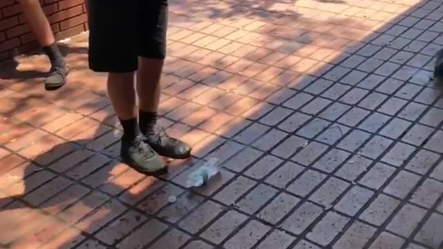 Kid in yellow shirt jumps on water bottle