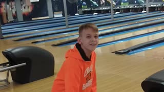 Boy orange sweater bowling ball falls in gutter