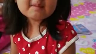 Cute indian Girl eating sour fruit