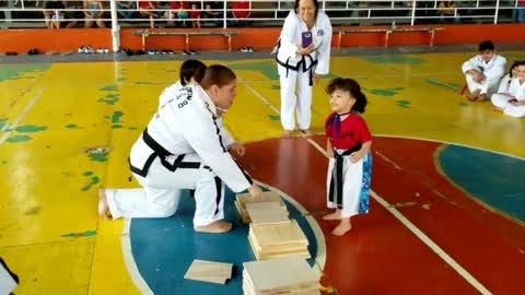 baby taewondo uses his body to smash the wooden planks