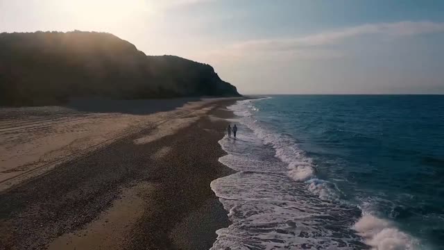 Couple Walking At The Seashore.