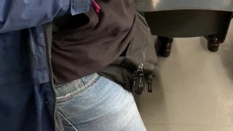 Guy fiddles with handcuffs on subway train