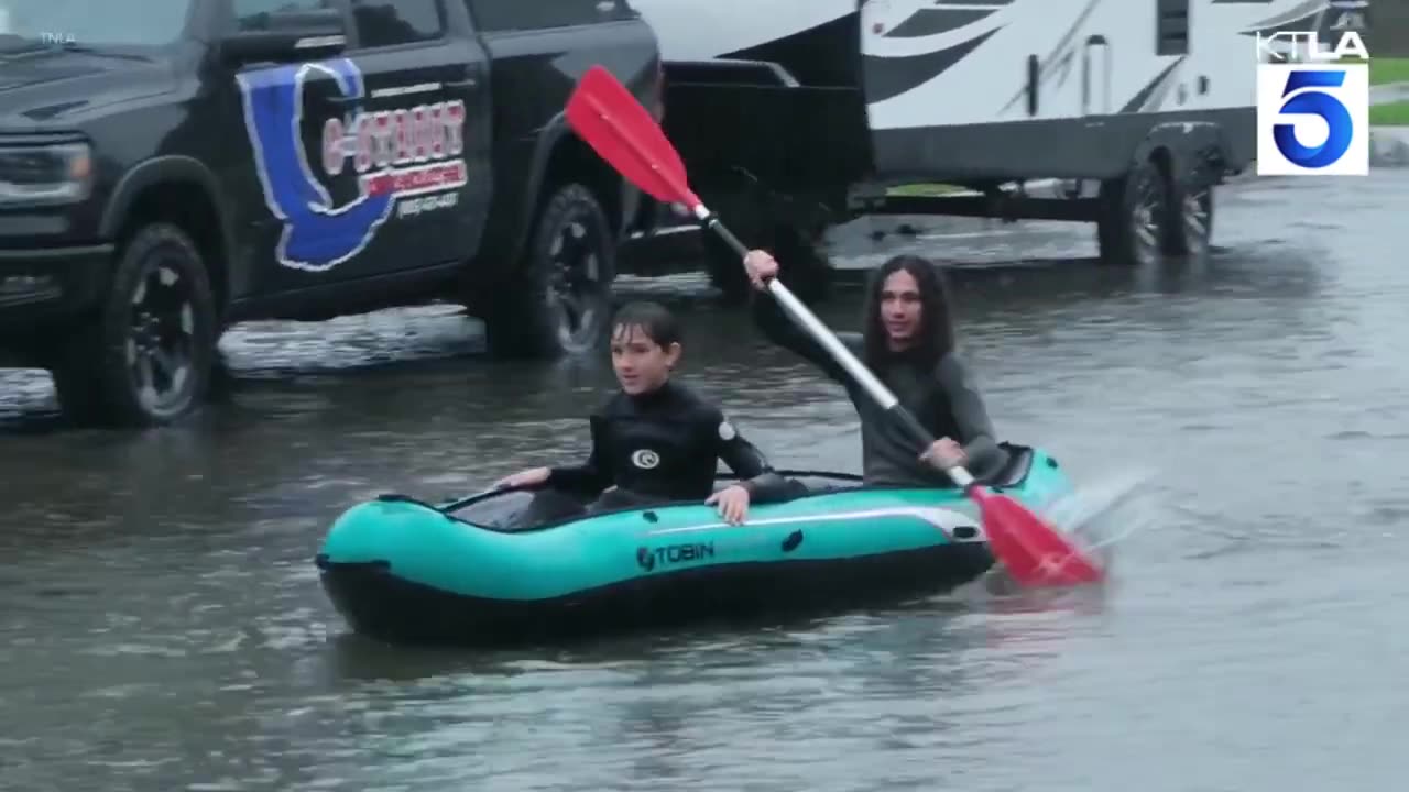 Locals surf on flooded street in Ventura, California