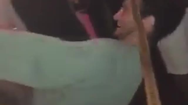 Guy in green sweatshirt falls down trying to limbo