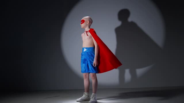 A Child Looking at a Camera while in a Super Hero Costume