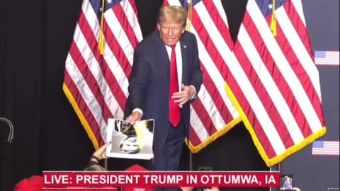 President Trump autographs his West Point picture from someone in the audience..
