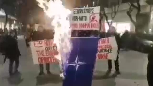 Greece demonstrators in Thessaloniki BURN NATO flag