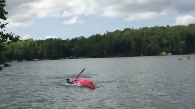 Yellow shorts throws beer at kayak and it knocks guy over