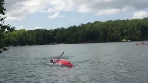 Yellow shorts throws beer at kayak and it knocks guy over