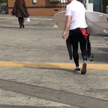 Guy asks white board man in parking lot which way to beach