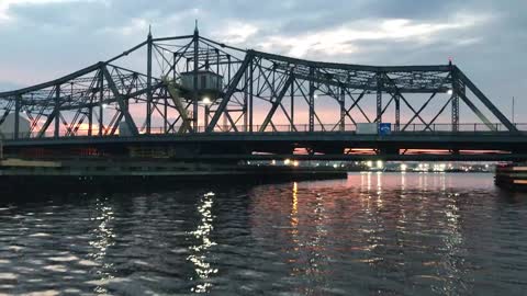 Boat squeezing under a bridge.