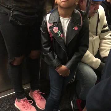 Young girl balances fidget spinner on forehead
