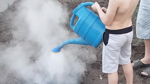 the boy puts out the fire with a watering can