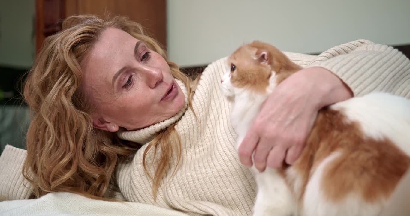 Woman Petting Her Cat On The Bed