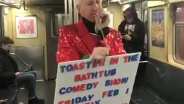 Old man in frog mask and red sequin suit does balloon animal trick