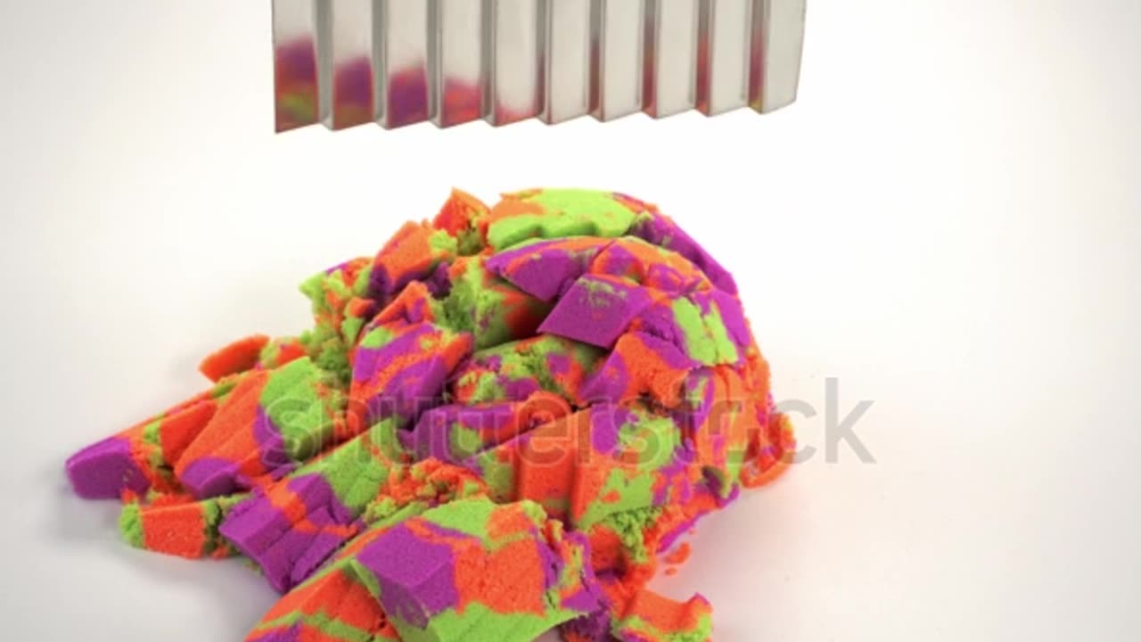 Kinetic sand cutting with a knife on a white background.