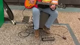 Man plays guitar station dog jumping police