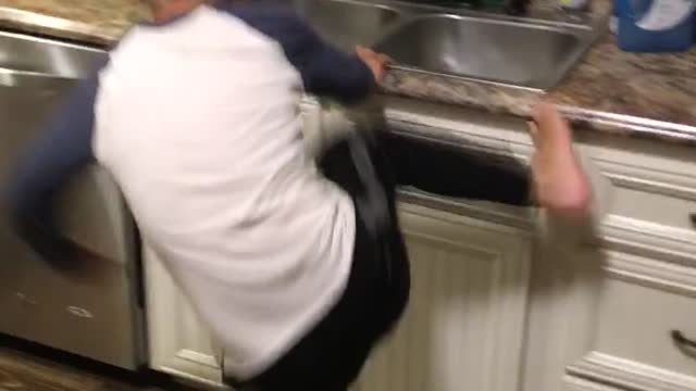 Kid boy runs to kitchen tries to kick leg onto sink hits leg instead