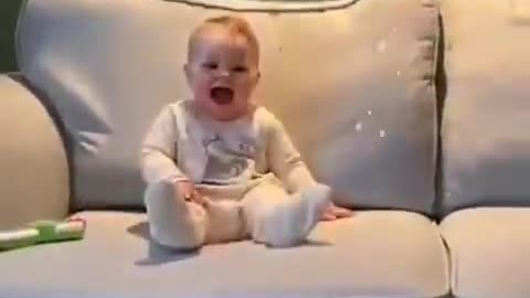 Kid laughing at cute dog who playing with bubbles