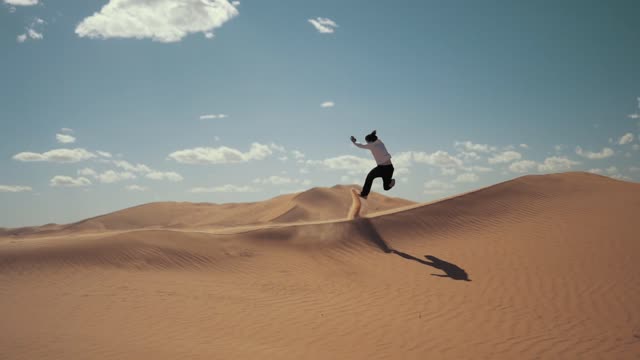 A Man Running Happily In A Sand Hill Of The Dessert