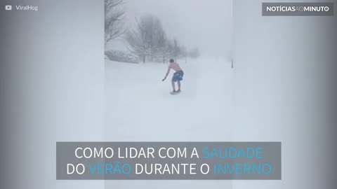 Jovem surfa na neve com traje de banho