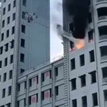 A drone extinguishes a fire in a burning high-rise building.